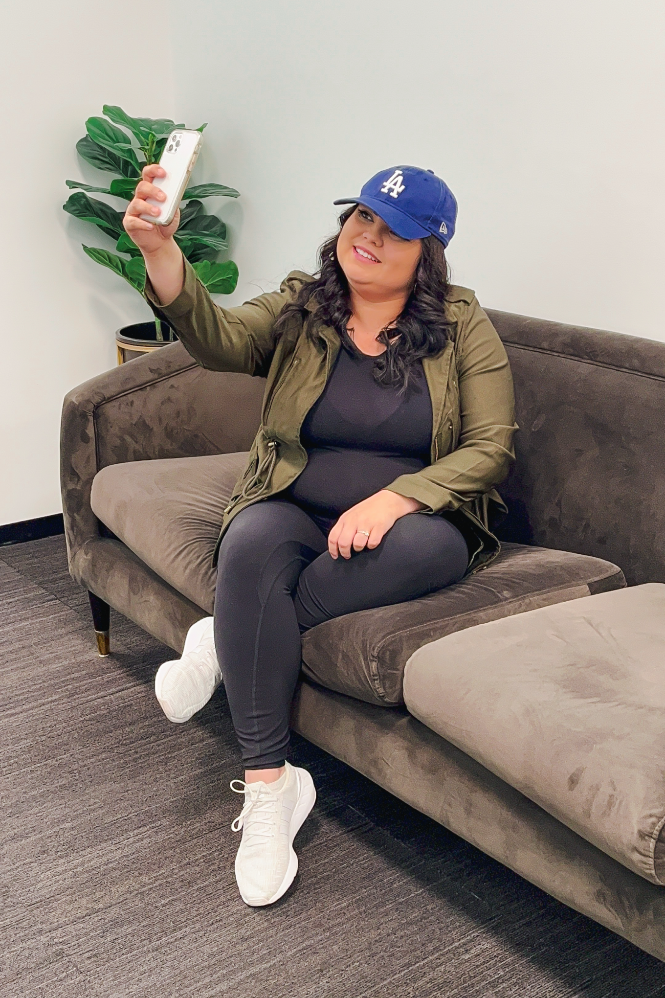Sam Arias lifestyle creator sitting on a couch taking a selfie, sharing favorite finds and shopping tips.